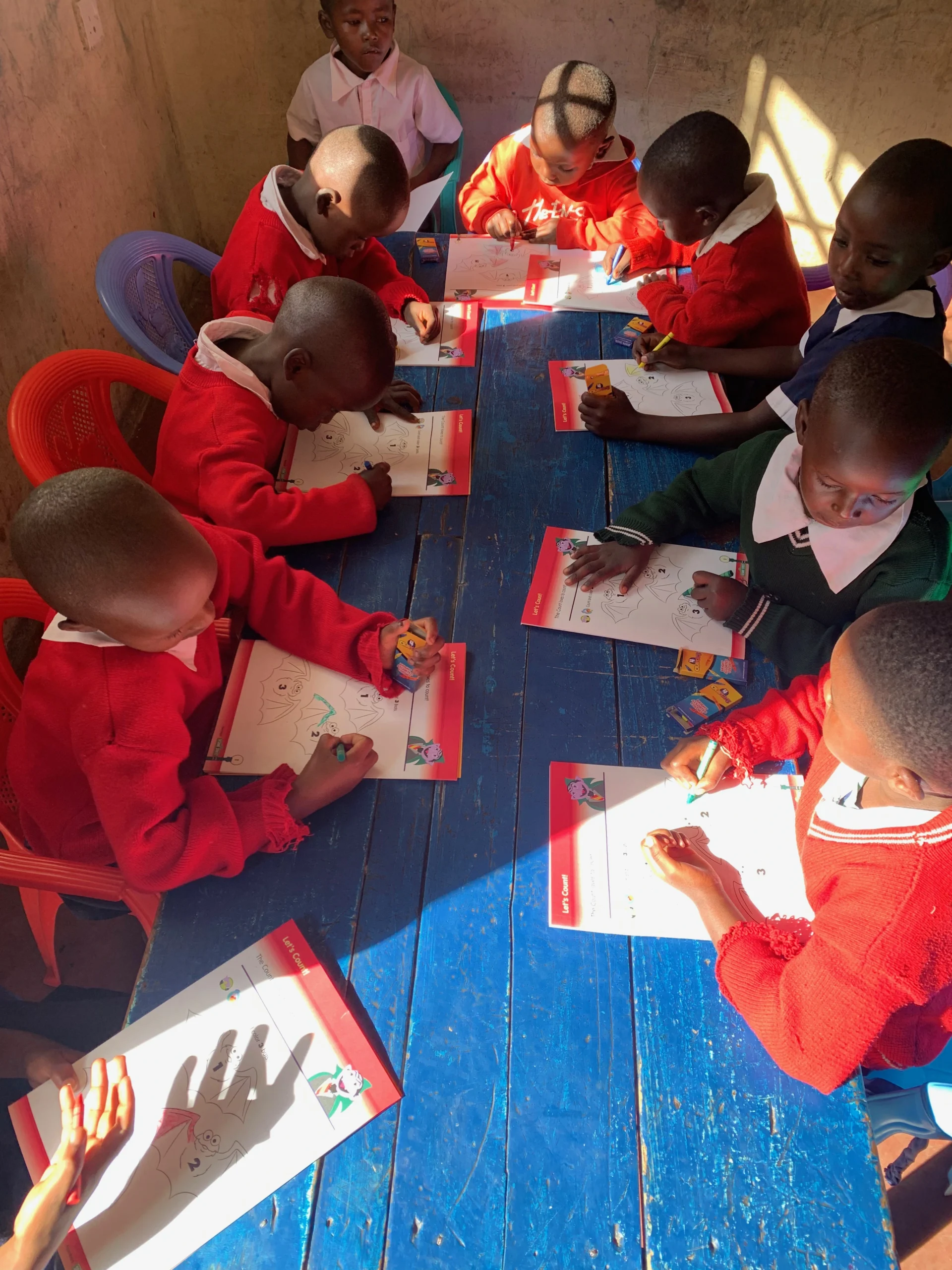 Children coloring at Wings of Hope Academy
